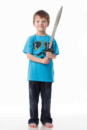 A little boy poses with a sword in a studioの写真素材