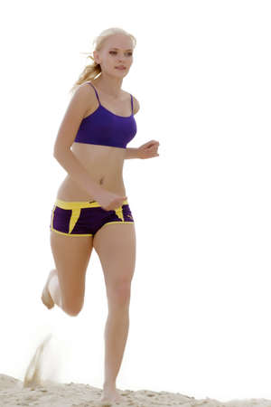Young woman runs on the sand.の写真素材