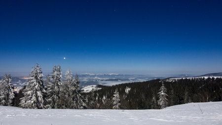 Fog moving over the mountain in winter with a star-shaped skyの写真素材