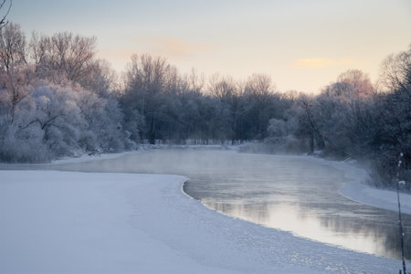 Photo the snow-covered river did not freeze in winter.The river flows in winter. Snow on the branches of trees. Reflection of snow in the river. Huge snowdrifts lie on the Bank of the stream.の写真素材
