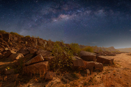 Milky Way over a lake in a granite quarry at night. Summer landscape with huge boulders, trees, purple sky with milky way and stars, beautiful reflection in the water. Ukraine. Space and nature.の写真素材