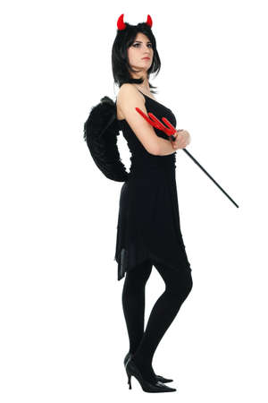 A beautiful, sexy woman in a devil costume, a demon with horns and pitchforks, a trident, in a red dress. American, dress for a costume party Halloween. Choker on the neck. Bright makeupの写真素材
