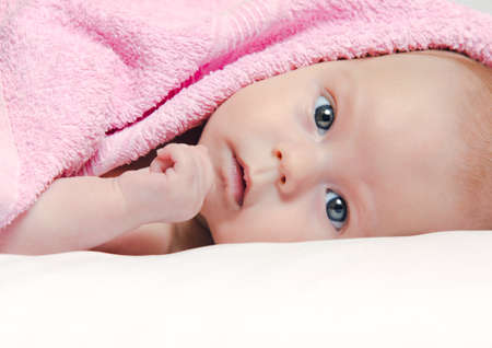 Baby girl After Bath Wrapped in Red Towel Laying and Posingの写真素材