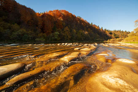View of the waterfall in autumn. Waterfall in autumn colors. Mountain river in the autumn landscape. Ukraine, river Stryj.の写真素材