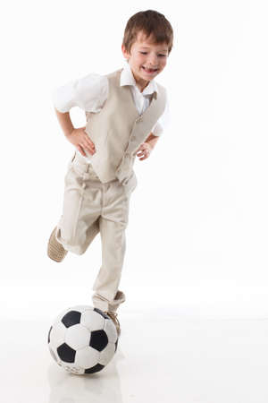 A sporty boy is playing with a soccer ball. Concept of a healthy lifestyle, sport and fitness. Isolated on white background.の写真素材