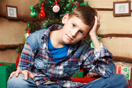 A boy near fir tree in New Years eveの写真素材