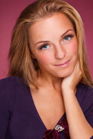 Fashion portrait of elegant young woman with curly blonde hair over pink backgroundの写真素材