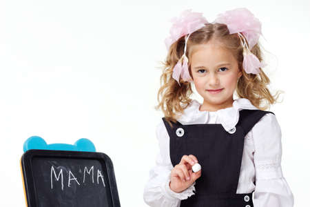 Portrait of a first grader in a school uniform on a white background.の写真素材