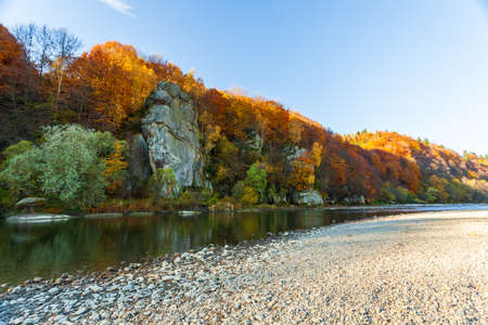 View of the waterfall in autumn. Waterfall in autumn colors. Mountain river in the autumn landscape....