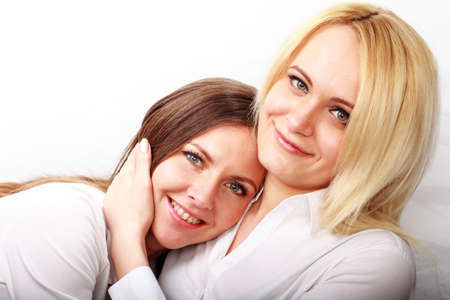 studio fashion image of two beautiful young women, isolatedの写真素材