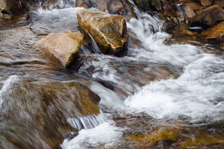 A small active waterfall. Clean mountain stream, snowy winter landscape, wildlife backgroundの写真素材