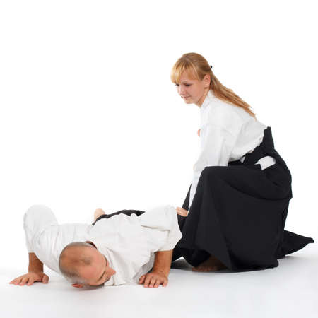Two people, a man and a woman, practice aikido on the mat. Isolated on white background.の写真素材