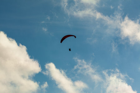 Paraglider flying over clouds in summer dayの写真素材