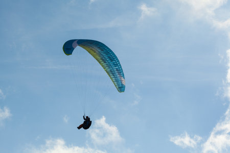 Paraglider flying over clouds in summer dayの写真素材