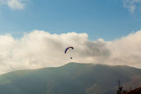 Paraglider flying over clouds in summer dayの写真素材