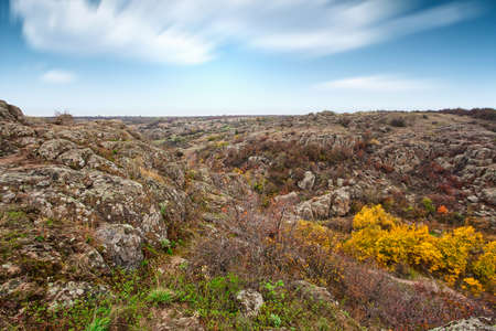 A large number of stone minerals covered with green vegetation lying above a small river in picturesque Ukraine and its beautiful natureの写真素材