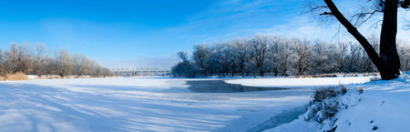 Photo the snow-covered river did not freeze in winter.The river flows in winter. Snow on the branches of trees. Reflection of snow in the river. Huge snowdrifts lie on the Bank of the stream.の写真素材