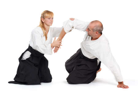 Two people, a man and a woman, practice aikido on the mat. Isolated on white background.の写真素材