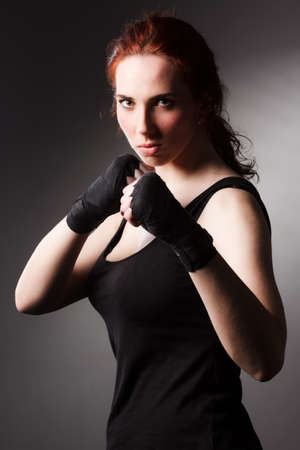 Fitness woman exercise stretch arms boxing weight punch in Dark background, studio lighting gradient gray top light shadow low exposure copy space, concept Woman Can Do Sport 6 packsの写真素材