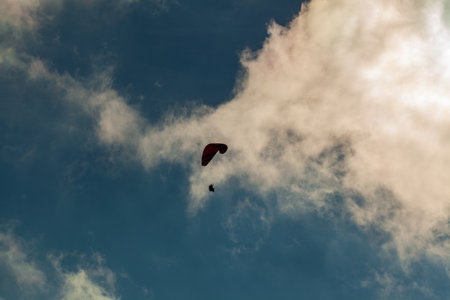 Paraglider flying over clouds in summer dayの写真素材