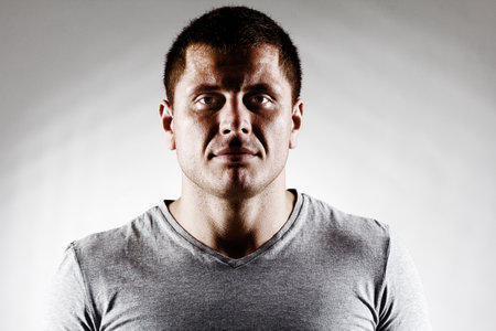 Portrait of strong healthy handsome Athletic Man Fitness Model posing near dark gray wallの写真素材