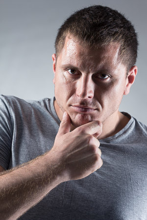 Portrait of strong healthy handsome Athletic Man Fitness Model posing near dark gray wallの写真素材
