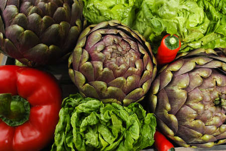 Fresh big Romanesco artichokes green-purple flower heads, red paprika, romanine lettuceの写真素材