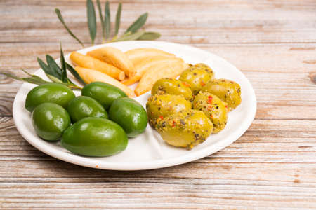 White board with giant  green olives and bread on wooden background, copy spaceの写真素材
