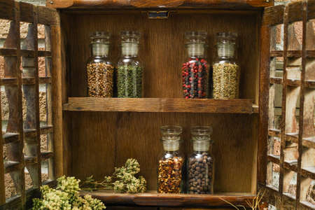 Farms vintage Spice Rack or Storage Cabinet: Wall Mount - Display Shelf, Two Drawers, Six Glass Bottles with oregano on rural background village lifeの写真素材