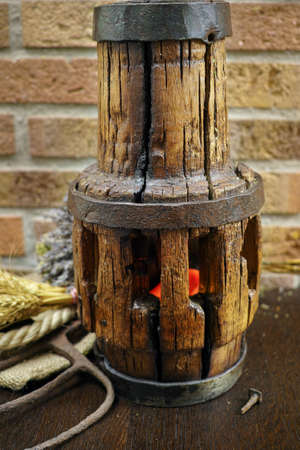 Antique pitchfork and wooden wheel hub against rural brick wall with lavender, whole wheatの写真素材