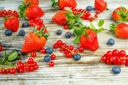 Variety fresh organic red and blue berry, strawberry on wooden background, copy spaceの写真素材