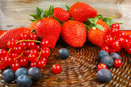Variety fresh organic red and blue berry, strawberry on wooden backgroundの写真素材