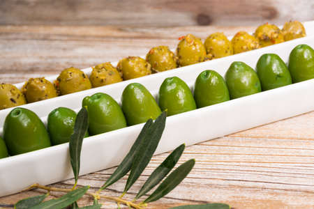 Tapas white board with giant  green olives and bread on wooden background, copy spaceの写真素材
