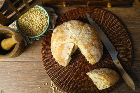 Round Loaf of Home made Bread with onion, whole wheat, in rural style on brick wall background