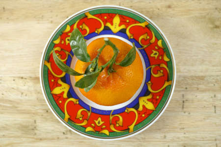 Fresh mandarin oranges fruit with green leaves on wooden backgroundの写真素材