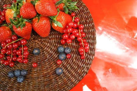 Variety fresh organic red and blue berry, strawberry on red background, copy spaceの写真素材