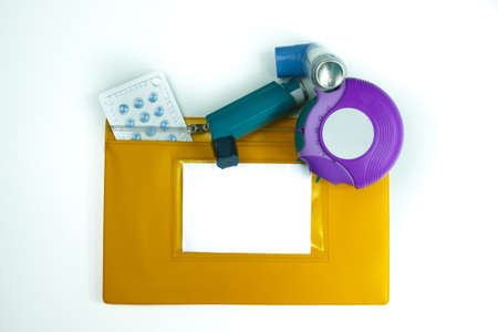 Asthma relief concept, salbutamol inhaler, another medication and yellow medical plastic bag, copy...