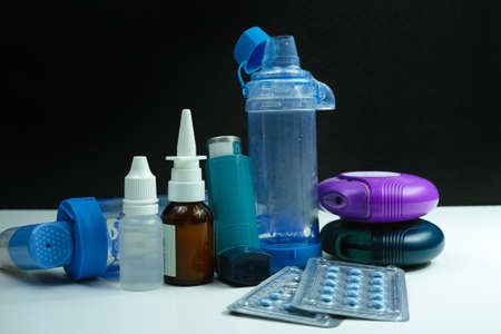 Asthma medication. Set of inhalers and medication for the treatment of bronchial asthma on a black...