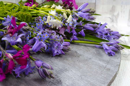 Bunch of fresh colorful flowers and hyacinths from the forest on wooden background, mothers day conceptの写真素材