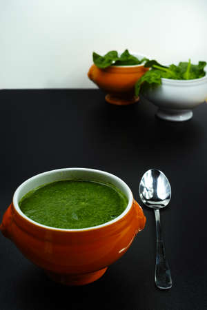 Fresh green spinach soup, cooking concept on black backgroundの写真素材