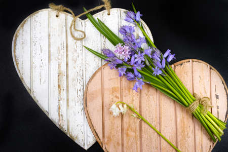 Bunch of fresh wild flowers hyacinths from the forest on wooden heartsの写真素材