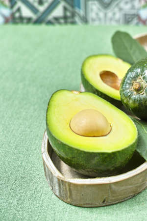 Fresh green avocado on colorful ornament background, copy spaceの写真素材