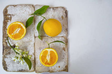 Fresh oranges with leaves and orange tree flowers on rustic wooden backgroundの写真素材