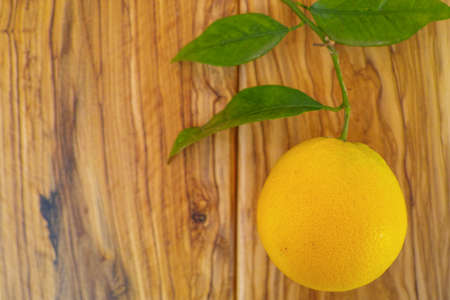 Fresh orange with leaves on olive wooden backgroundの写真素材