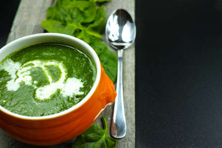 Fresh green spinach soup, cooking concept on wooden and black backgroundの写真素材
