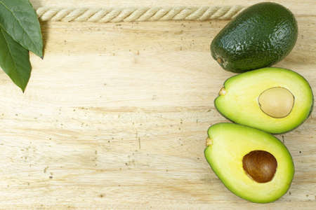 Fresh green avocado on wooden background, copy space