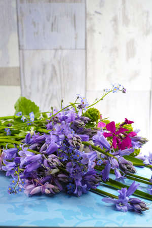 Bunch of fresh colorful flowers and hyacinths from the forest on wooden background, mothers day conceptの写真素材