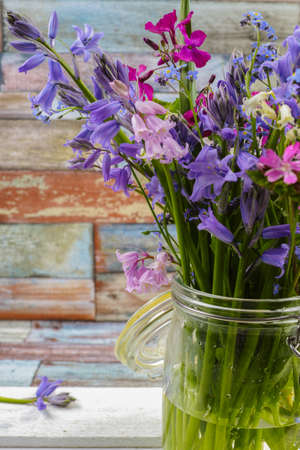 Jar with fresh colorful bouquet spring forest flowers and hyacinths, mothers day conceptの写真素材