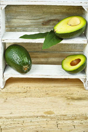 Fresh green avocado on wooden background, copy space