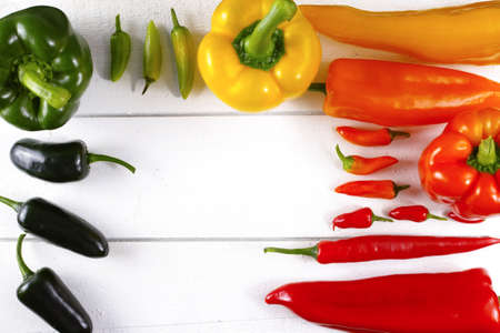 Mexican hot chili peppers colorful mix paprika poblano serrano jalapeno on white wooden boardの写真素材